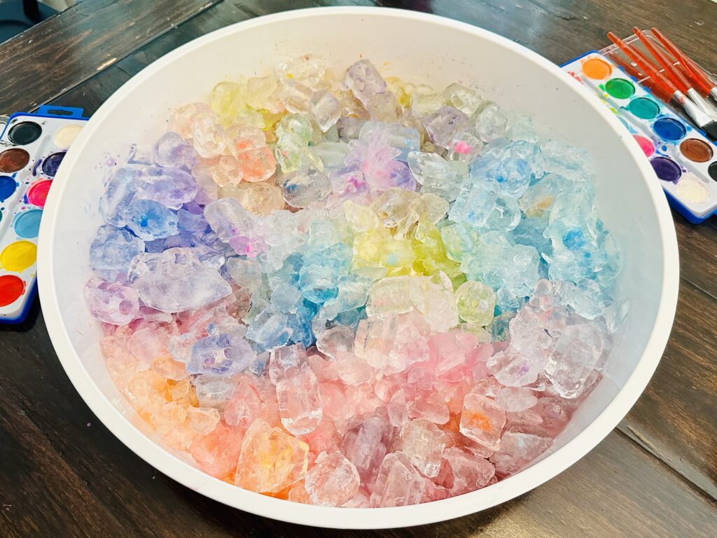 Sensory Bin filled with painted ice cubes.