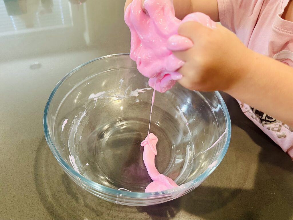 Child kneading homemade slime. 