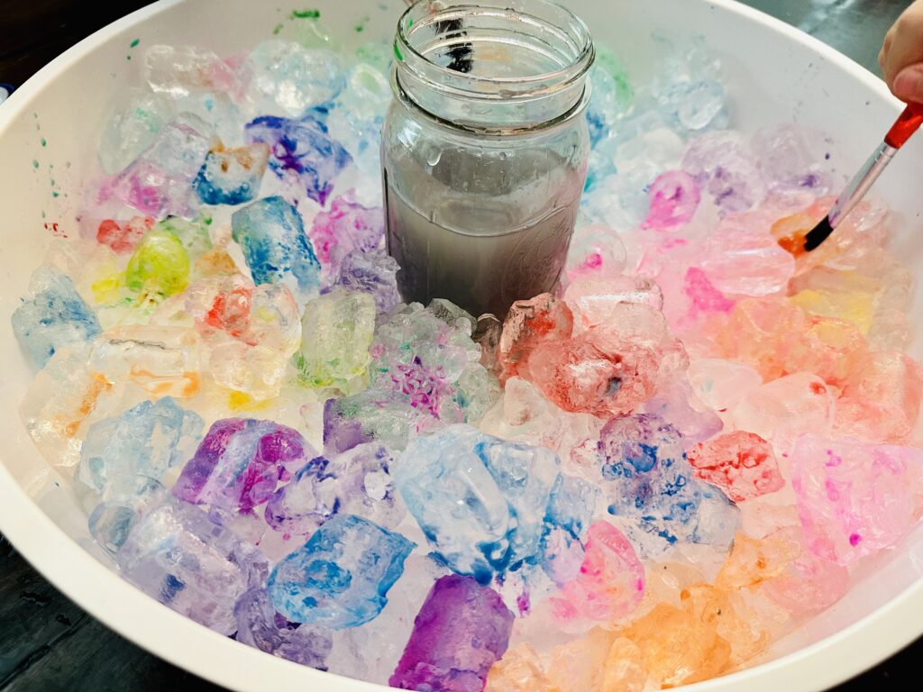 Sensory Bin filled with painted ice cubes.