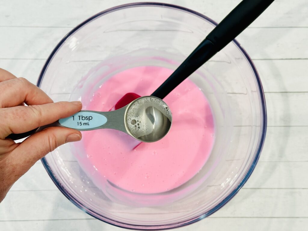 Mixing in contact solution to the glue and baking soda mixture in a bowl
