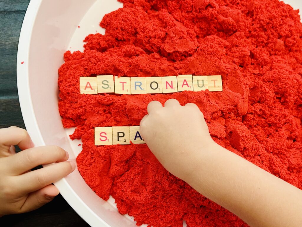 Child's Hands Playing With Space Themed Sensory Bin