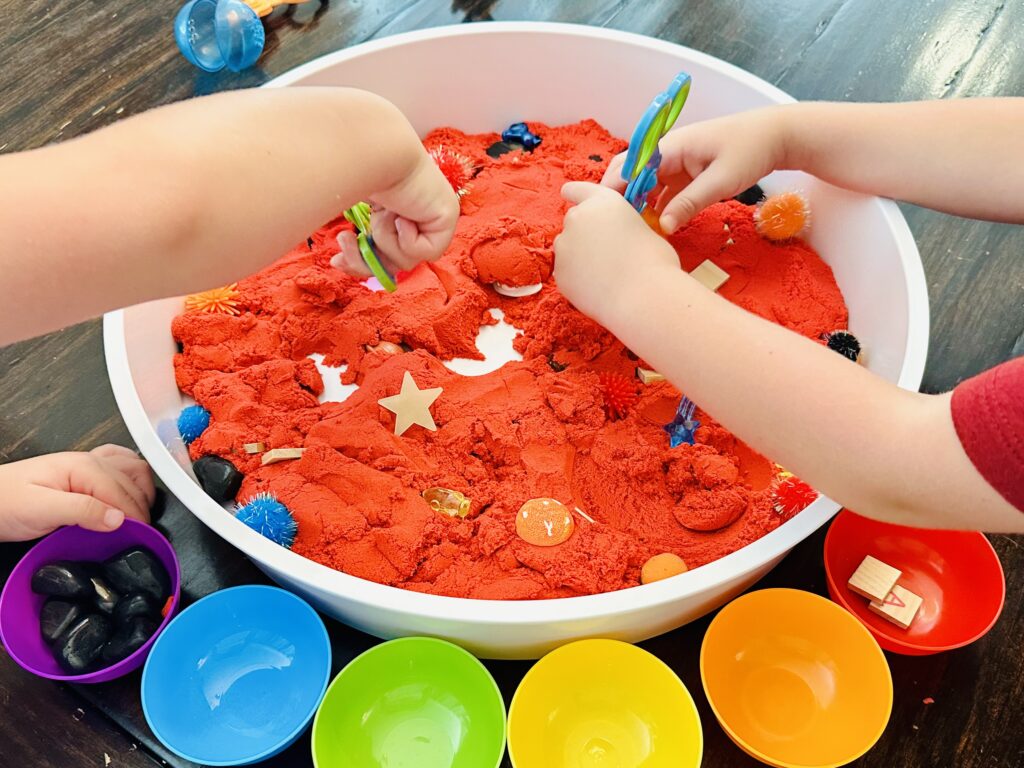 Childen's Hands Playing With Space Themed Sensory Bin