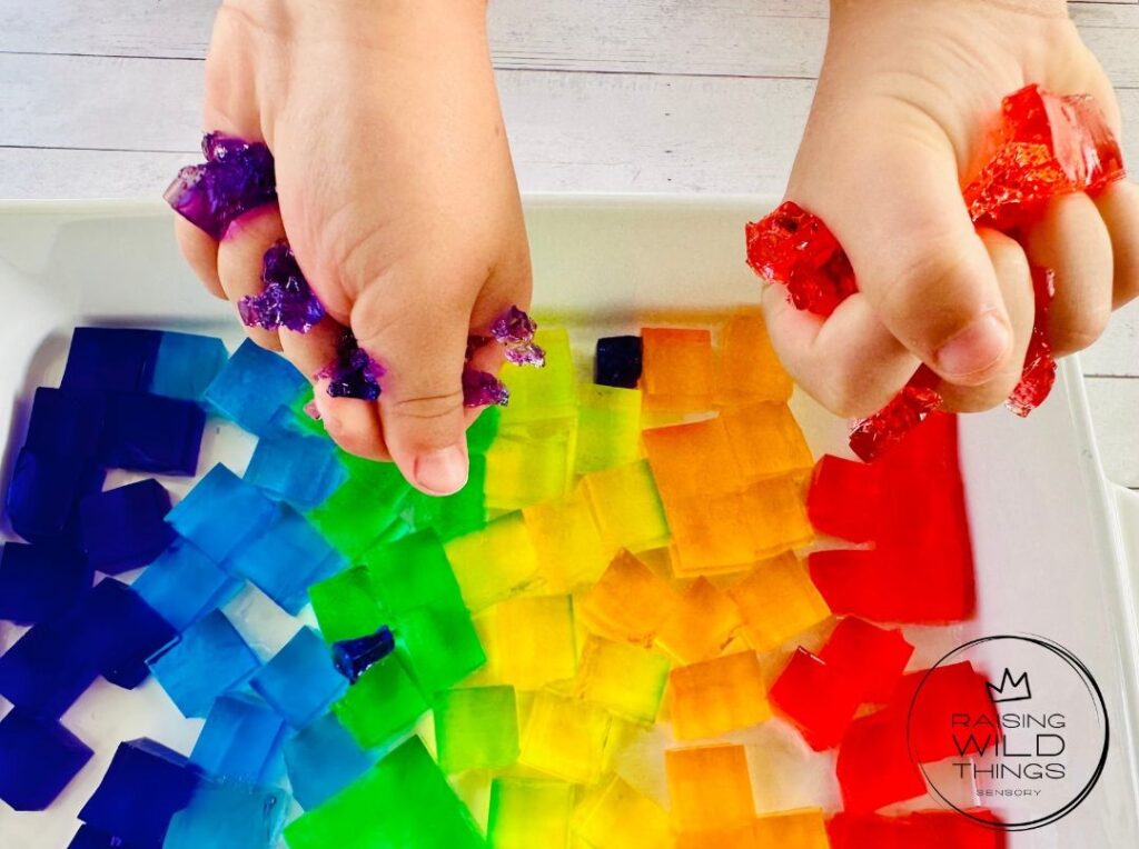 Kid's hands squeezing and squishing the jello blocks.