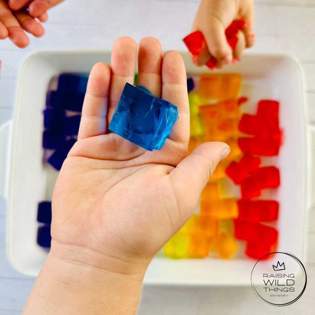 Kid's hands holding a single jello block.