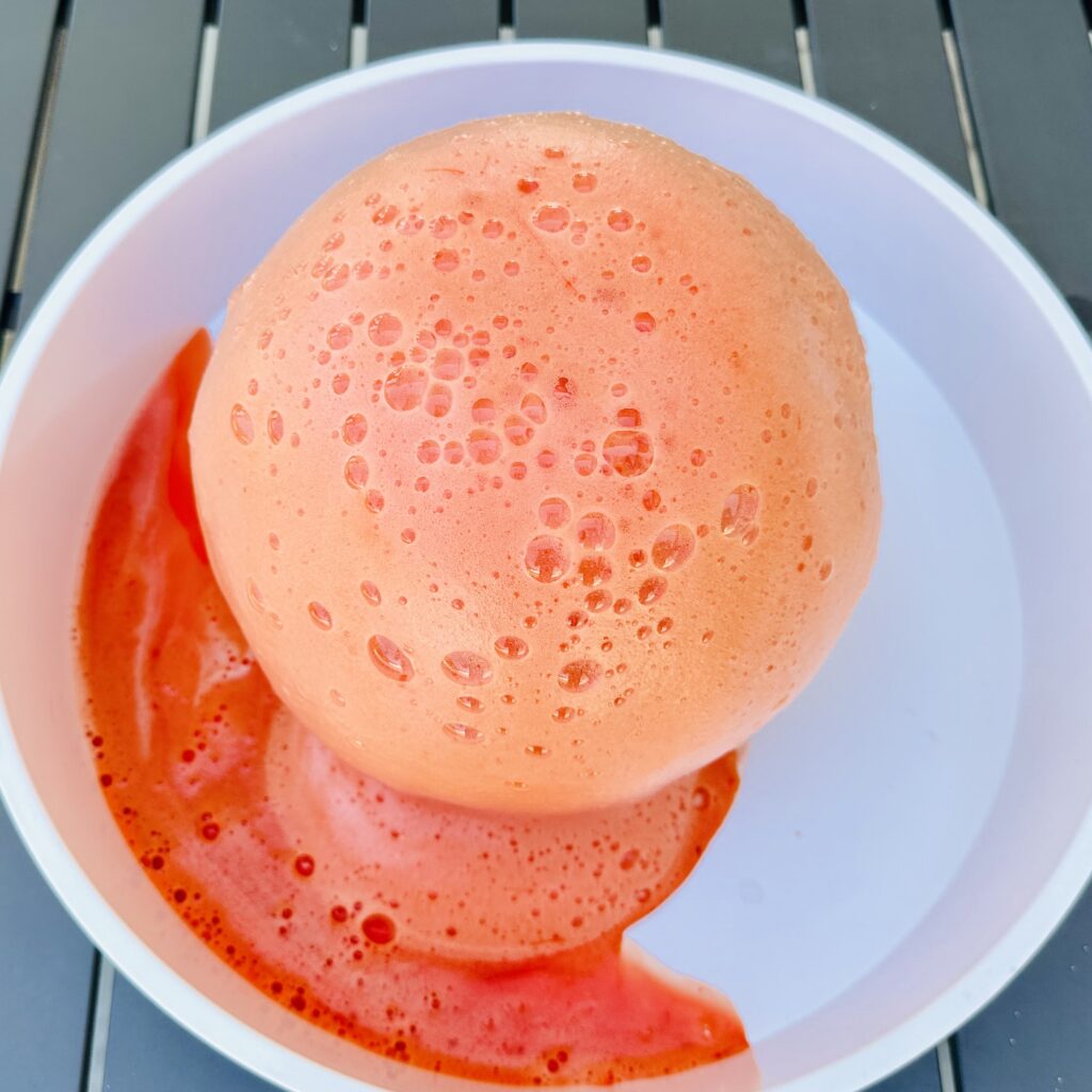 Colorful eruption after mixing vinegar with the baking soda, soap, and food coloring in the pumpkin.