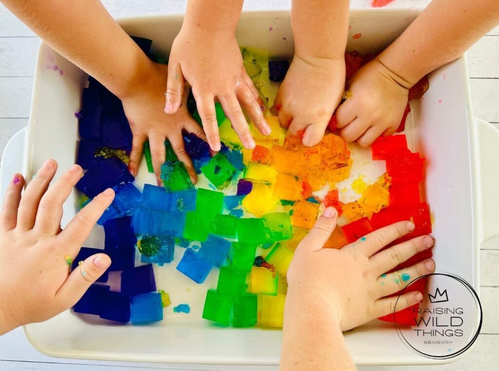 Kid's hands squeezing and squishing the jello blocks.