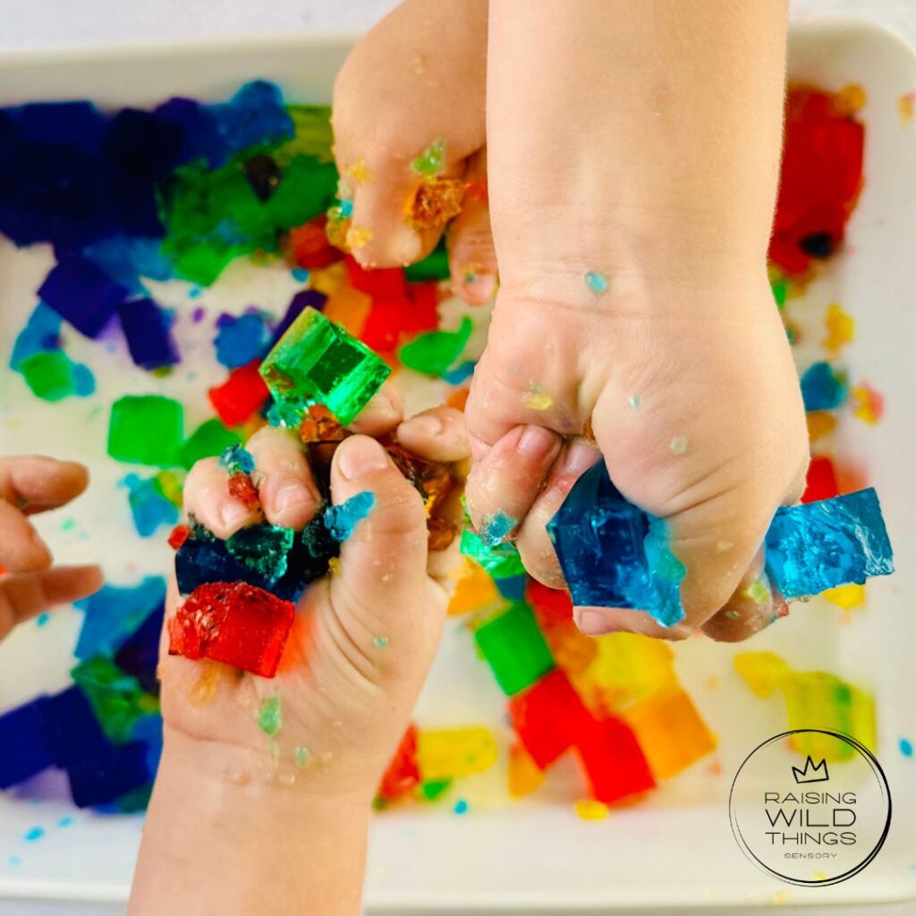 Kid's hands squeezing and squishing the jello blocks.