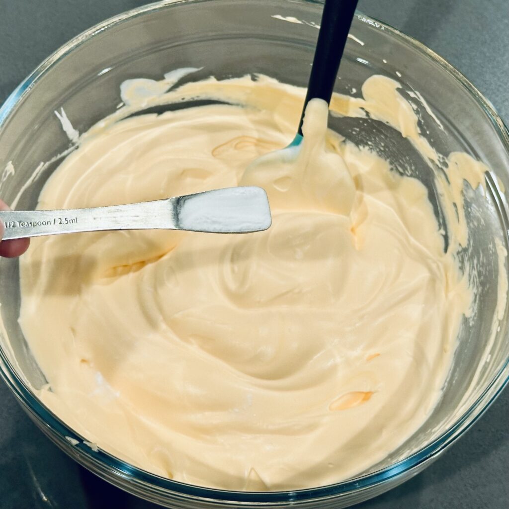 Mixing baking soda into fluffy pumpkin slime.