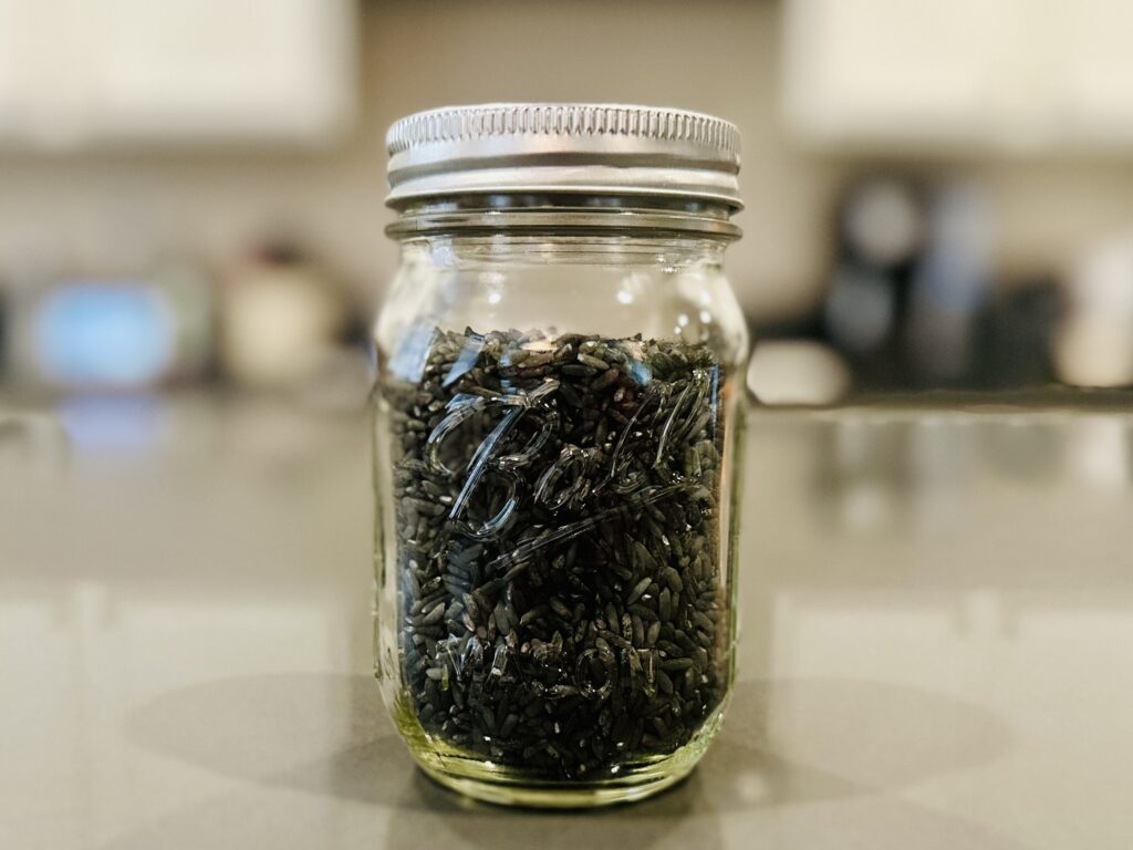 Dyed black rice in a glass mason jar for storage.