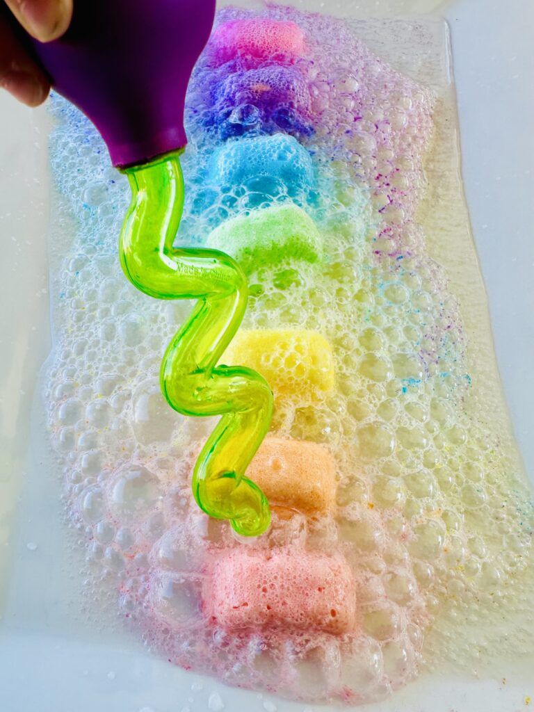 Dropper squeezing vinegar on a frozen fizzy cube on a baking dish