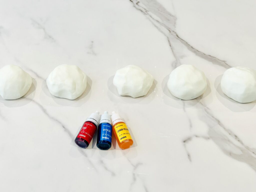 White cloud dough divided into ball to add food coloring to each ball