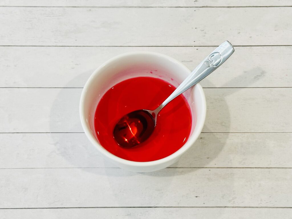 Food coloring and water combined in a bowl to make Valentine's Day Fizzy Heart Ice Cubes