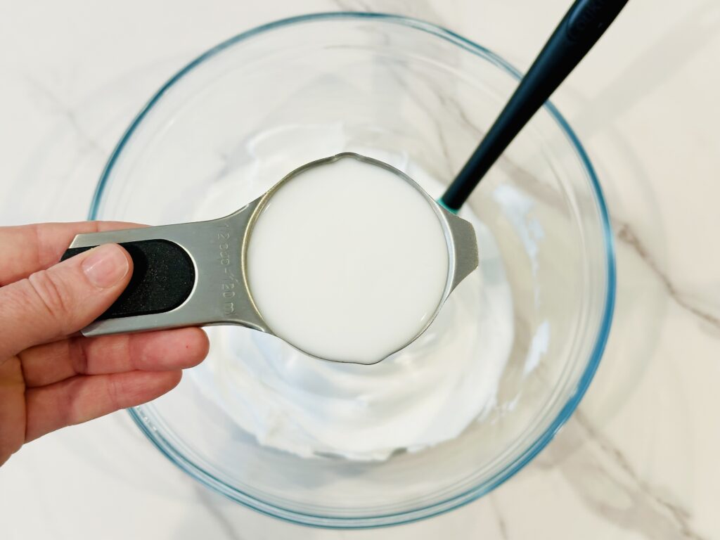 Adding glue to the mixing bowl with shaving cream