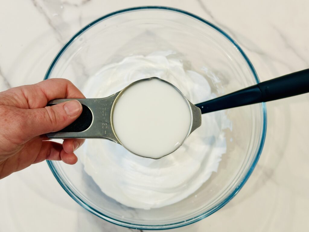 Adding glue to the mixing bowl with shaving cream