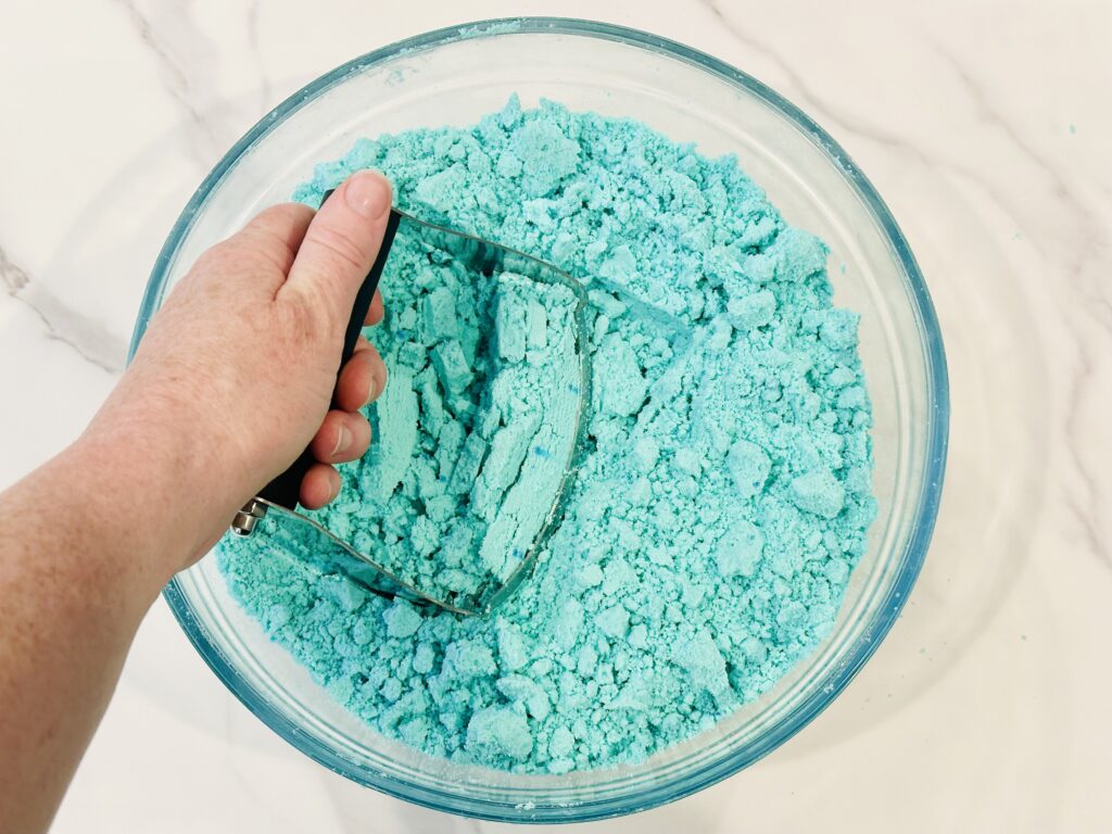 Using a pastry cutter to work the oil and food coloring into the dough