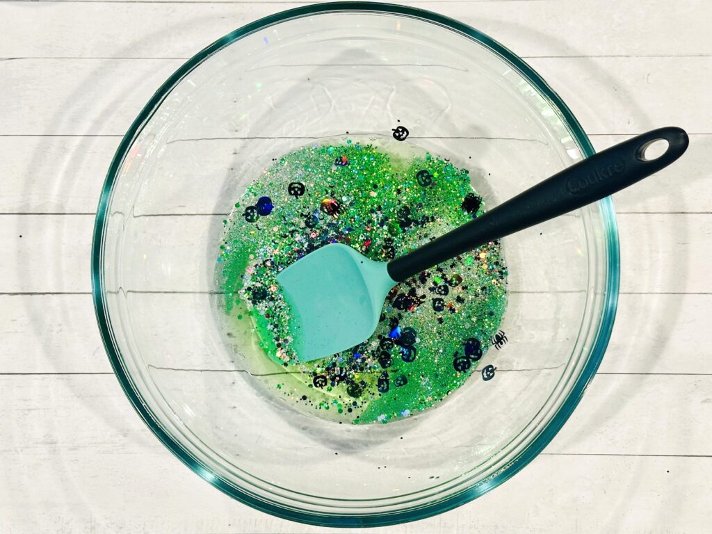 Adding food coloring, glitter, and confetti to the slime mixture