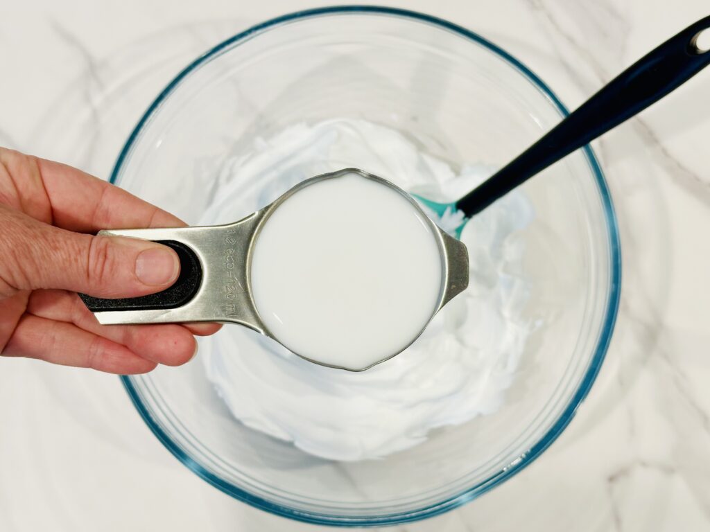 Adding glue to the mixing bowl with shaving cream